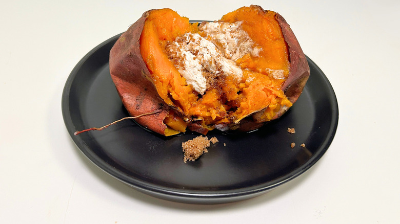 A black plate of Texas Roadhouse sweet potato against a white background