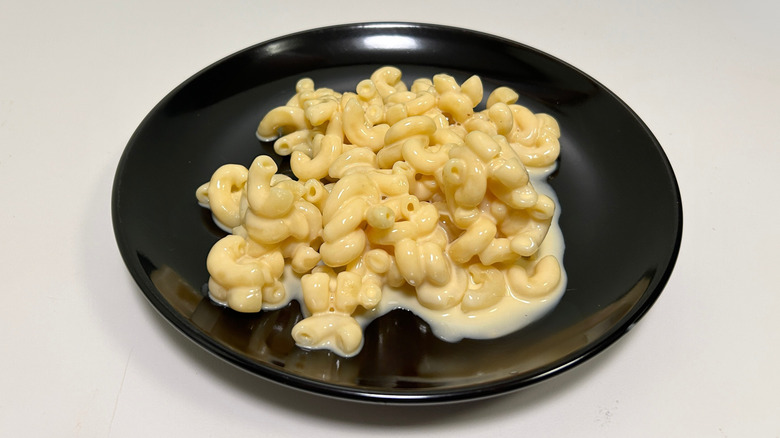 A black plate of Texas Roadhouse mac and cheese against a white background