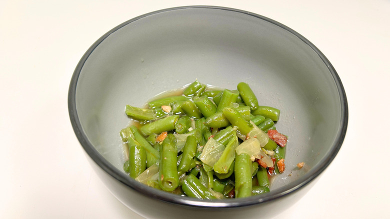 A black bowl of Texas Roadhouse green beans against a white background