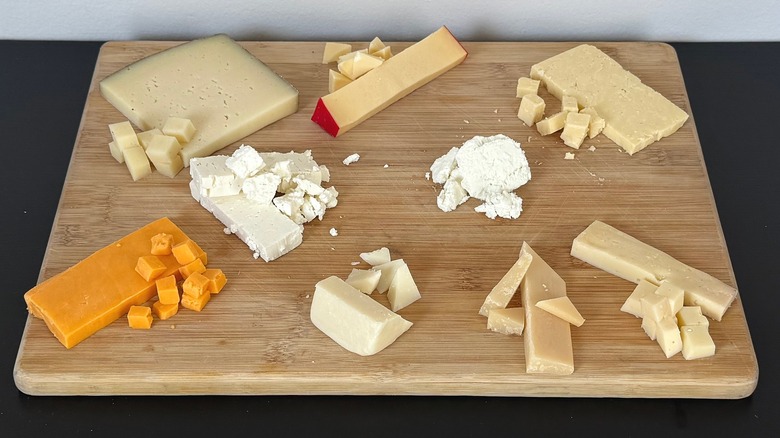 Various cheeses on wood cutting board