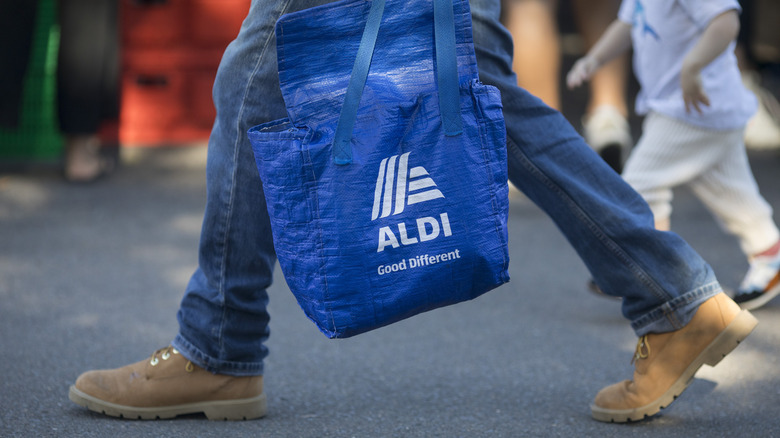 Person carrying reusable Aldi bag
