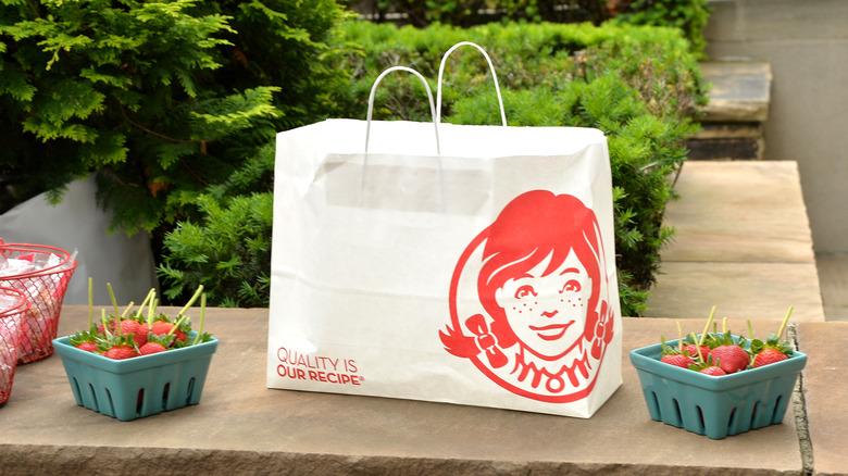 Wendy's takeout bag next to boxes of strawberries