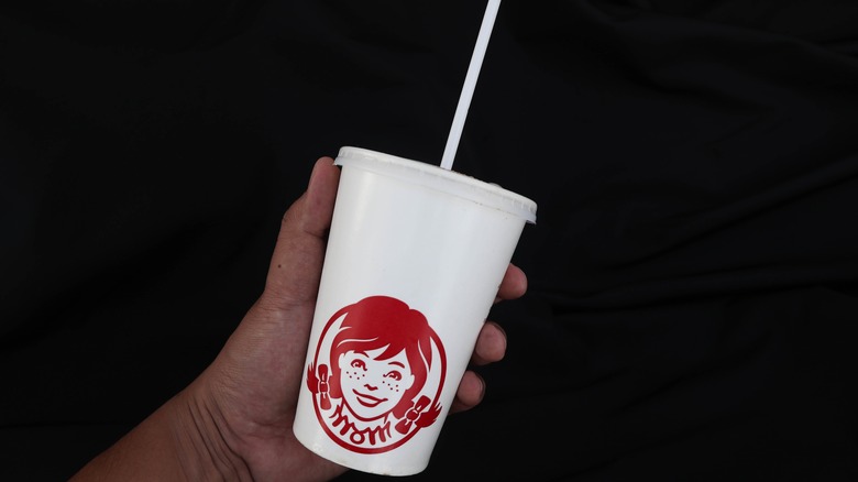 A person holding a Wendy's cup
