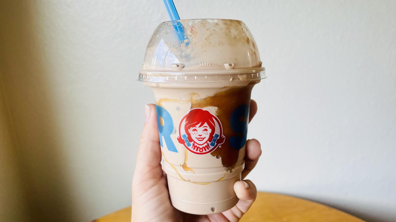Hand holding Wendy's Chocolate Snickerdoodle Cookie Fusion Frosty