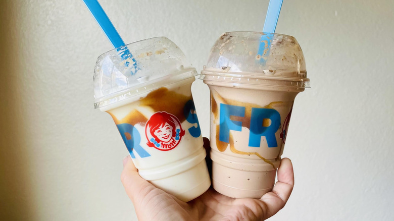 Hand holding two Wendy's Snickerdoodle Cookie Fusion Frostys