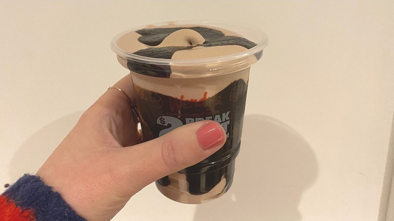 Holding Chocolate Frosty in hand