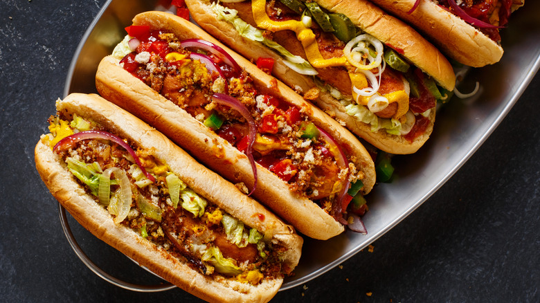 Hot dogs on rolls with various toppings 