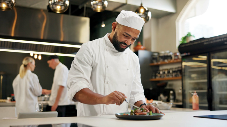 chef plating a meal in a restaurant kitchen