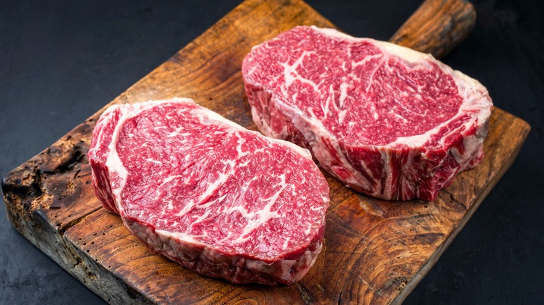 Two raw steaks on a cutting board