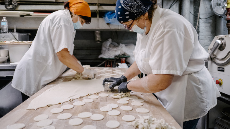 Kitchen staff cutting pierogi dough