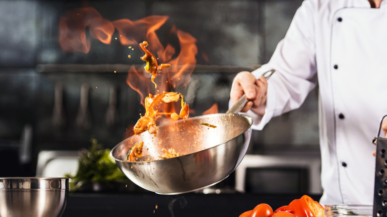chef with wok on fire
