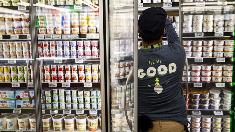 A Whole Foods employee restocks yogurt