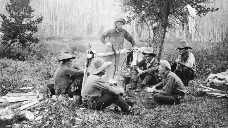 photo of cowboys around a fire waiting for dinner