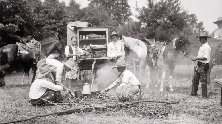 cowboys prepare dinner over a fire