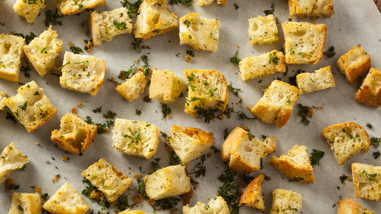 Homemade croutons covered in parsley and olive oil
