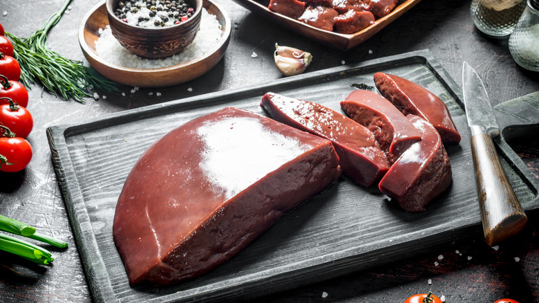 Raw liver on board with knife