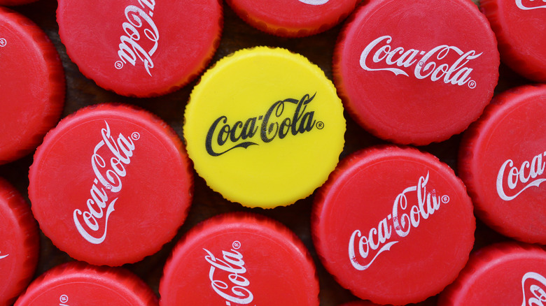 yellow Coca-Cola cap among red caps
