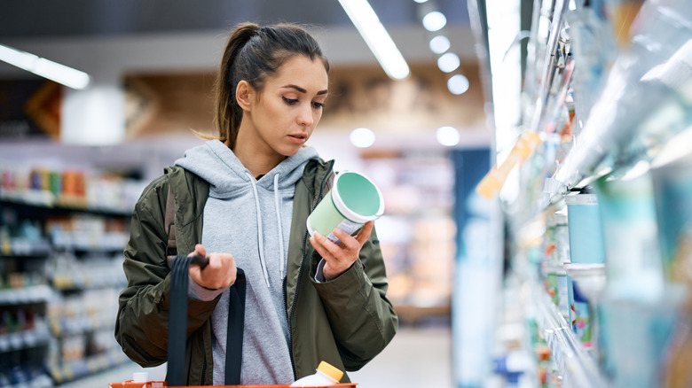 Person inspecting food label at grocery store