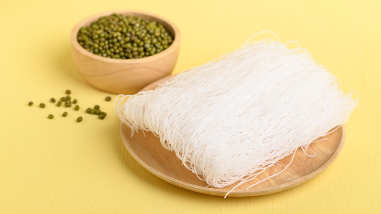 Uncooked glass noodles on wooden plate