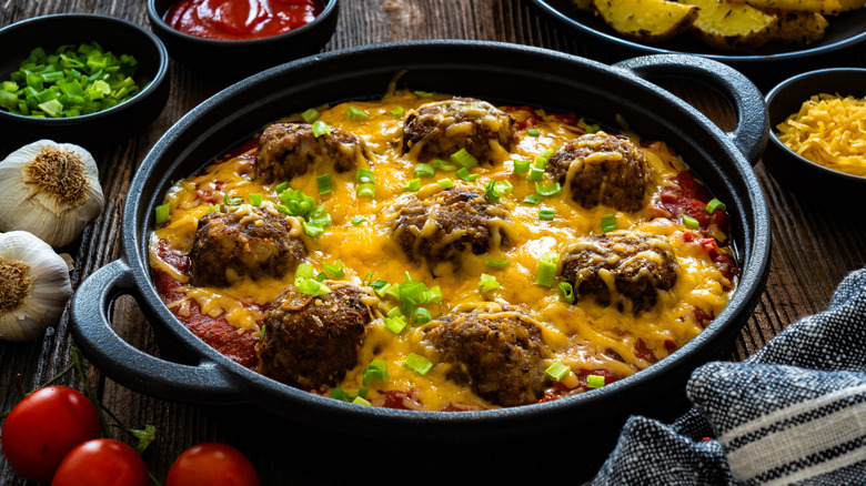 Cowboy-style meatballs, baked in one cast iron pot with cheddar cheese and a tomato sauce