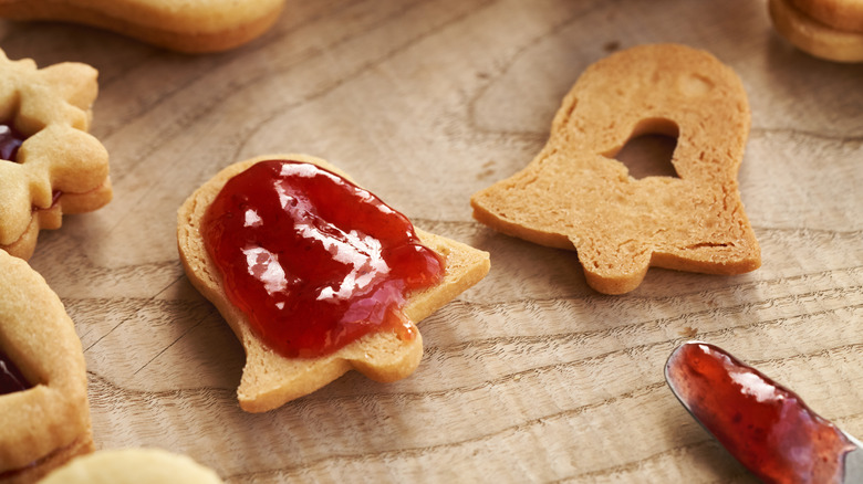 Bell-shaped Linzer Christmas cookies filled with strawberry jam