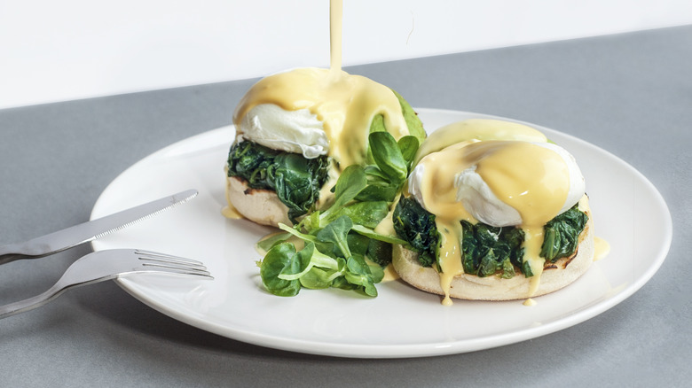 Hollandaise pouring our eggs florentine 