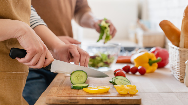 chopping vegetables on a cutting board with a kitchen knife