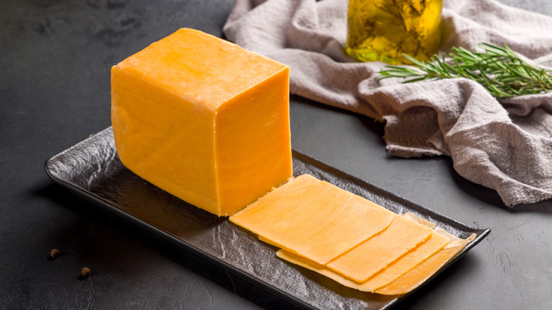 A block of sliced cheddar cheese on counter