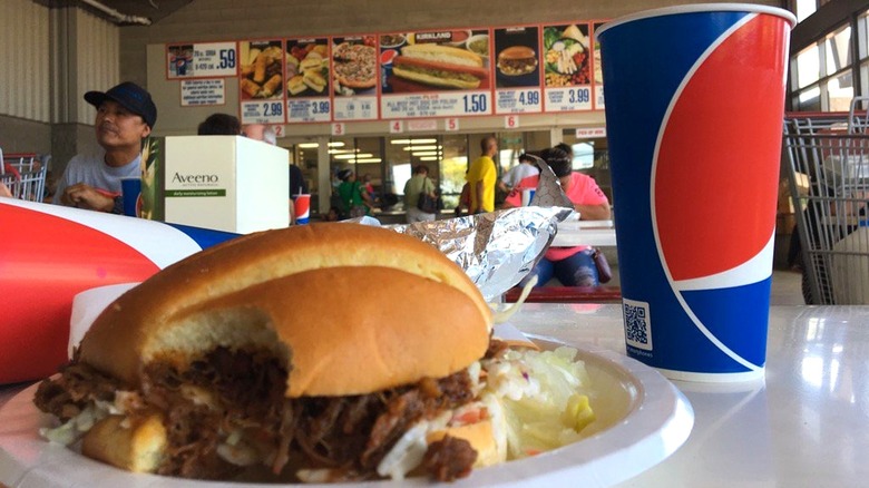 A juicy brisket sandwich from costco on a paper plate inside food court
