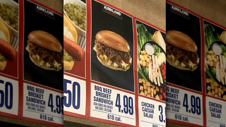 A Costco menu board featuring the bbq beef brisket sandwich
