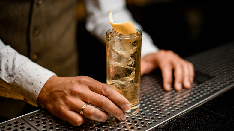 bartender holding highball drink