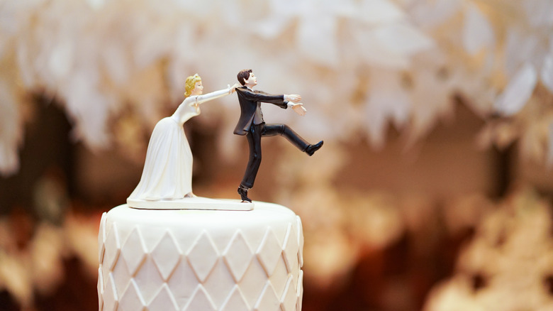 wedding cake with topper featuring bride and groom