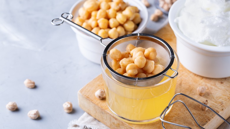 chickpeas being strained into aquafaba