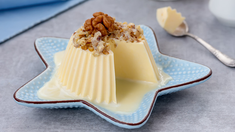 a Bavarian cream molded dessert topped with a sauce and nuts 