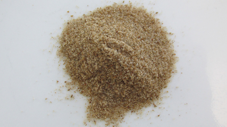 Close up of a pile of celery salt on a white background