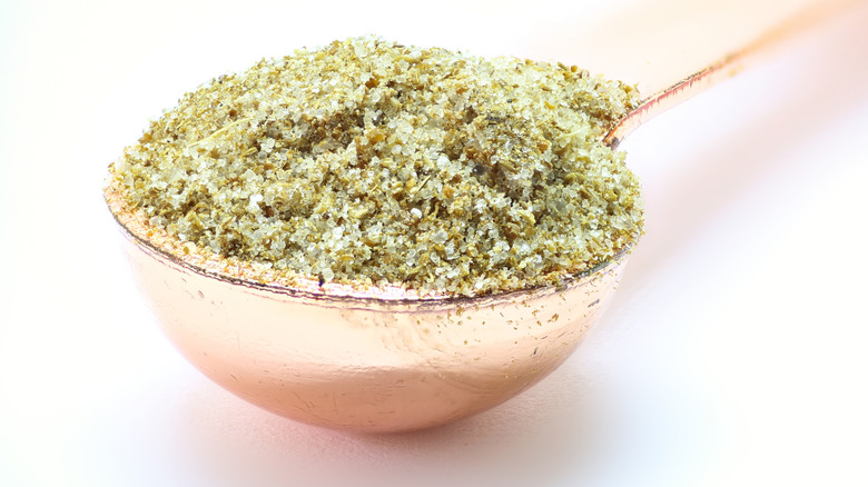 Celery salt in a spoon on a white background