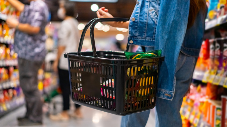 Woman holding supermarket basket in a supermarket