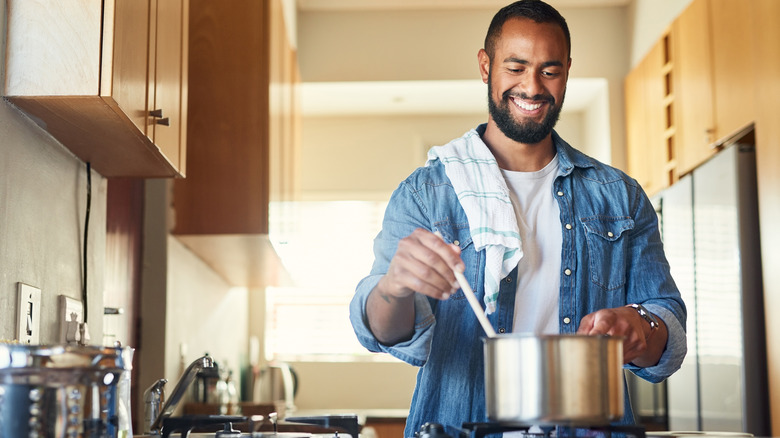 man stirring pot on the stove