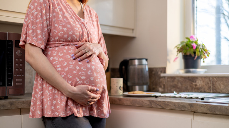 Pregnant person in kitchen