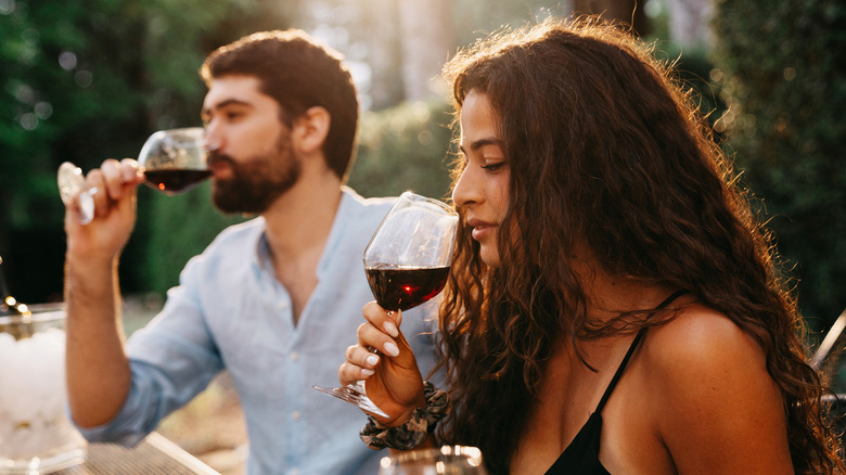 man and woman tasting wine