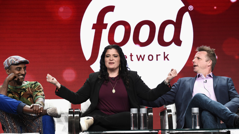 Panel of judges from "Chopped" on a stage