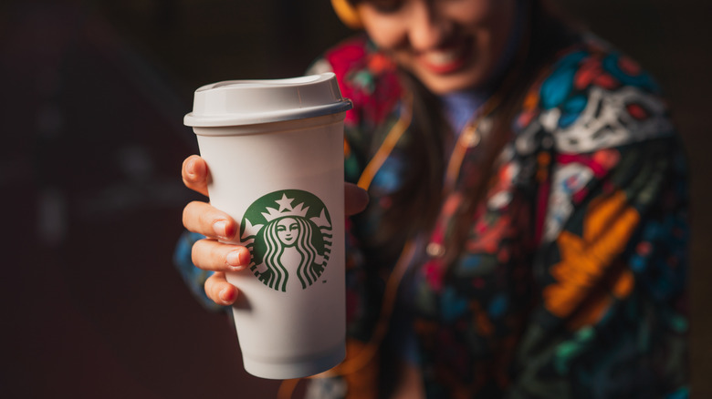 smiling woman holding Starbucks