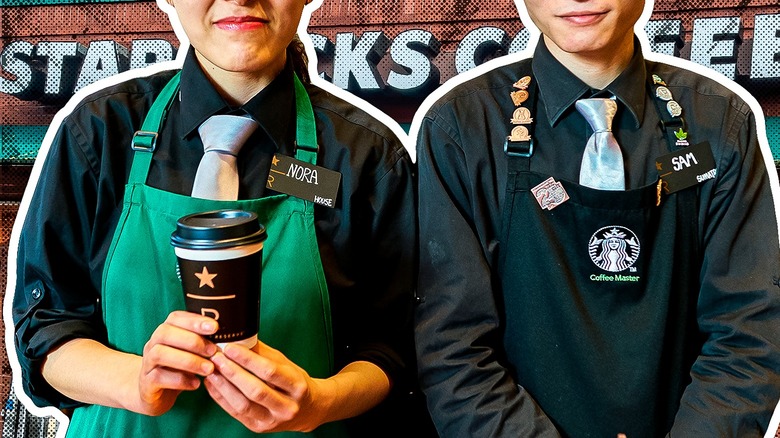 two starbucks employees holding drinks