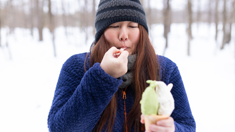 Woman eating ice cream in the snow