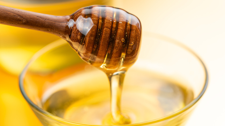 Close-up on a honey spoon dripping honey