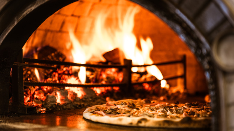 wood-fired pizza in front of oven