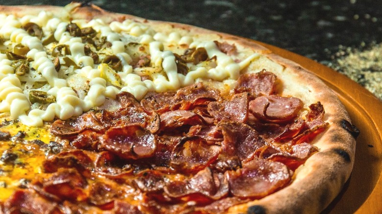 Half pepperoni and half cheese pizza on wooden board