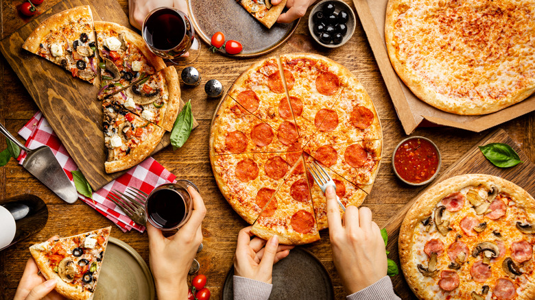 Wood table with various pizza types scattered on top