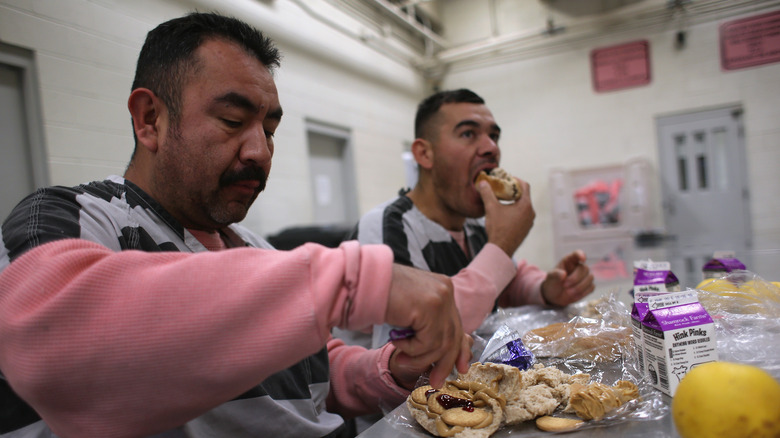 Prison inmates eating sandwiches