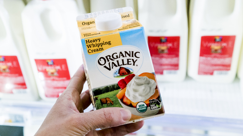 Hand holding heavy whipping cream